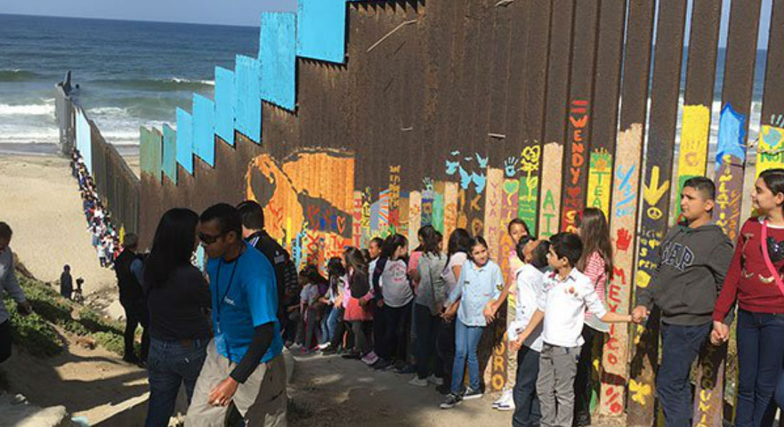 Niños cantan por solidaridad en muro fronterizo de Tijuana