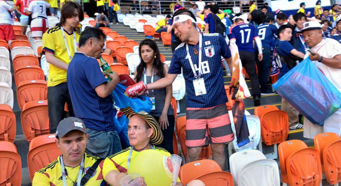 Fans japoneses limpian el estadio tras el partido de su selección