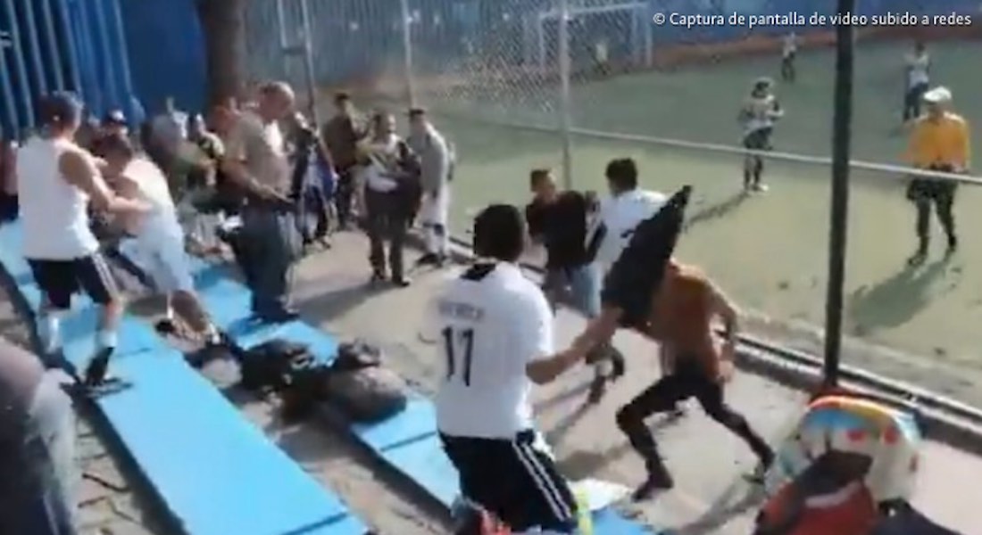 VIDEO: Dan castigo a niños que jugaban futbol mientras los adultos se agarraban a golpes