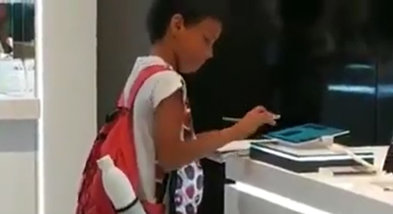 Niño hace su tarea con tablet de exhibición en tienda